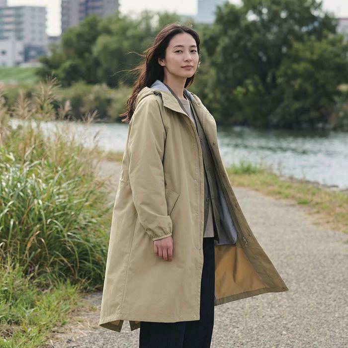 コートを着て川沿いを歩く女性